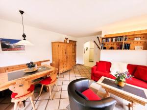 Una sala de estar con un sofá rojo y una mesa. en Curtins18, en Pontresina