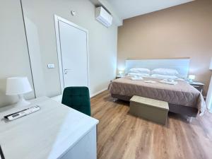 ein Schlafzimmer mit einem Bett, einem Schreibtisch und einem Tisch in der Unterkunft B&B Ovidio in Catania