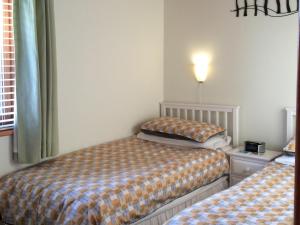 EllonbyにあるLarchwoodのベッドルーム1室(ベッド2台付)、壁にランプが備わります。 +8枚の写真