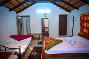 a bedroom with two beds in a room at Green Palaces Homestay in Avathi