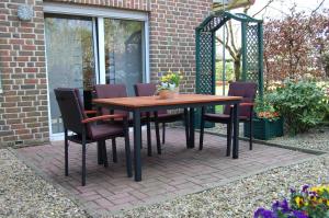 a wooden table and chairs on a patio at Wohnung In Reckenfeld Mit Eigener Terrasse in Greven