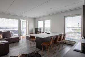 a living room with a table and chairs and a couch at Penthouse Serena Tampere in Tampere
