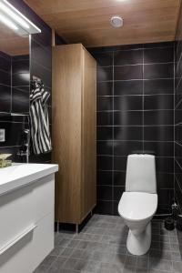 um banheiro com um vaso sanitário branco e uma pia em Penthouse Tampere & Jacuzzi hyvillä maisemilla em Tampere mais 5 fotografias