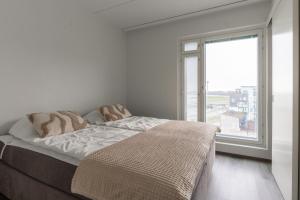 a bedroom with a bed and a large window at Penthouse Serena Tampere in Tampere
