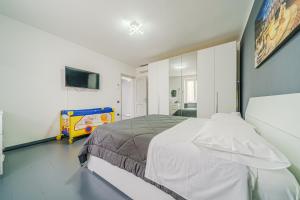 a bedroom with a bed and a tv and a crib at Casa Francesco - close to the airport & private parking in Azzano San Paolo