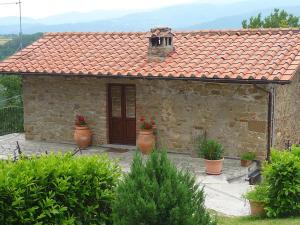 プラトヴェッキオにあるGeraneiの前に植木鉢が置かれた小さな石造りの家