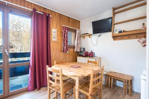 a dining room with a wooden table and a window at Centre Valloire - Studio Cabine in Valloire +17 photos