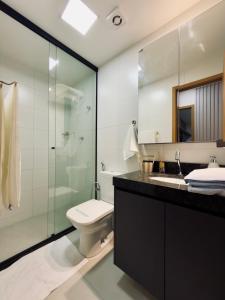 a bathroom with a toilet and a glass shower at Studio Desing 3 - Alva in Maceió