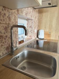 eine Spüle aus Edelstahl in einer Küche mit einem Spiegel in der Unterkunft Adriatic Houses Borse in Bašanija + 54 Fotos