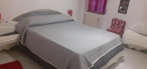 a white bed in a room with a chair at la casa di ALEX in Rionero in Vulture