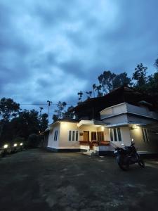 a house with a motorcycle parked in front of it at Cloud Wayne in Sultan Bathery