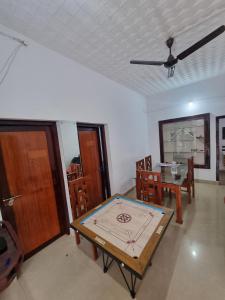 a room with a ping pong table and a dining room at Cloud Wayne in Sultan Bathery