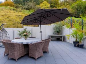a table and chairs with an umbrella on a patio at Waldklang Panorama in Alpirsbach