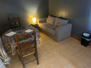 een woonkamer met een bank en een tafel bij La maison de Bonnevel in Civray-de-Touraine