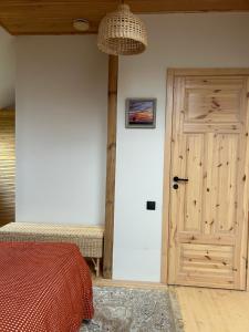 a bedroom with a wooden door and a bed at MūsMājas in Talsi