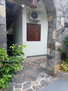 una entrada a una casa con una puerta de madera en Dihini Villa, en Unawatuna