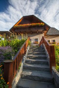 a staircase leading to a house with flowers on it at Penzion pod Šerákem in Ostružná