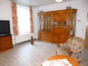 a living room with a tv and a couch and a chair at Ferienwohnung Im Vierseitenhof in Annaberg-Buchholz