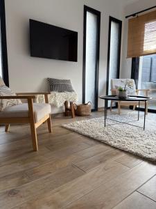 a living room with a table and a tv on a wall at LE REFUGE DE LA BAIE in Beaussais sur Mer