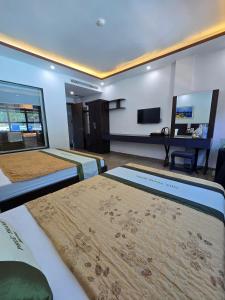 a hotel room with two beds and a flat screen tv at La Maison in Cat Ba +30 photos