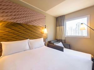 サンパウロにあるibis Sao Paulo Ibirapueraの大きなベッドと窓のあるホテルの部屋