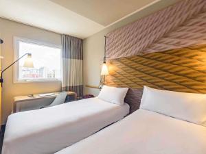 a hotel room with two beds and a window at ibis Sao Paulo Ibirapuera in São Paulo +87 photos