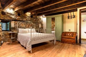 ein Schlafzimmer mit einem Metallbett und einem Stuhl in der Unterkunft Ruralmedulas Casa 2 in La Campañana