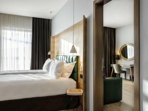 ein Hotelzimmer mit einem Bett und einem Spiegel in der Unterkunft Tarcin Forest Resort & Spa Sarajevo - MGallery Collection in Tarčin