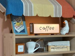 a toy shelf with a coffee sign and other items at Lilia's Cozy Duplex In The City Center in Yerevan