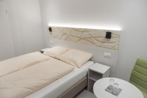 a small room with a bed and a table at C&M Hotel in Hamburg