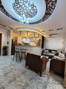 a living room with a stone floor and a chandelier at Dar El Ommda in Tozeur