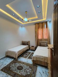 a bedroom with two beds and a ceiling at Dar El Ommda in Tozeur