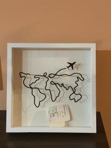 a framed picture of a map of the world with a plane at Lilia's Cozy Duplex In The City Center in Yerevan
