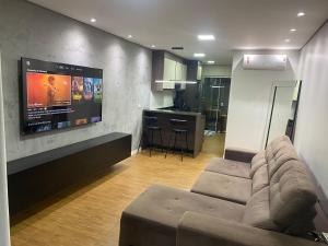 Una sala de estar con un sofá y un televisor de pantalla plana. en Banheiro INDIVIDUAL, Garagem Coberta e TV com streamings, en Campo Mourão