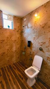 a bathroom with a toilet and a window at Mitra Palolem in Canacona