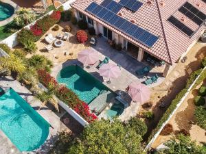 an aerial view of a house with a swimming pool with umbrellas at Luxurious Custom-built Villa Pool Spa Fire Pit more in Palm Desert