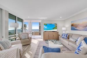 a living room with white furniture and a view of the ocean at Island Beach Club #320E in Sanibel