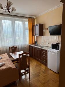 a kitchen with a sink and a table with a dining room at Hercules in Truskavets