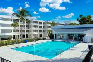 a swimming pool in front of a building with a resort at Island Beach Club #320E in Sanibel