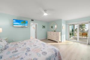 a bedroom with a bed and a dresser and a mirror at Island Beach Club #340E in Sanibel +45 photos