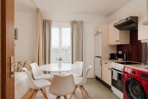 eine Küche mit einem Tisch und Stühlen sowie eine Küche mit einem Fenster in der Unterkunft Relaxing Cozy Condo Family-Friendly in Central Mariahilfer in Wien
