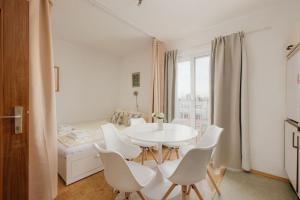 ein weißes Esszimmer mit einem weißen Tisch und weißen Stühlen in der Unterkunft Relaxing Cozy Condo Family-Friendly in Central Mariahilfer in Wien