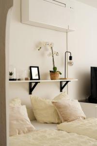 ein Bett mit Kissen und ein Regal an der Wand in der Unterkunft Relaxing Cozy Condo Family-Friendly in Central Mariahilfer in Wien