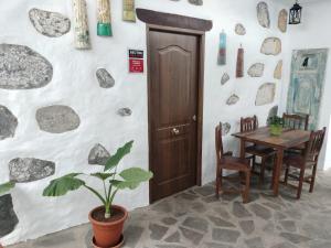 a dining room with a table and a plant at Casa Gloria, encanto canario entre montaña y mar in Arucas