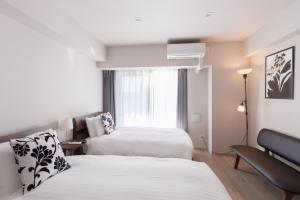 ein Hotelzimmer mit zwei Betten und einem Fenster in der Unterkunft LANG HOTEL Kameido - Vacation STAY 79478v in Tokio