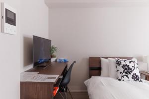 Schlafzimmer mit einem Schreibtisch, einem Computer und einem Bett in der Unterkunft LANG HOTEL Kameido - Vacation STAY 79478v in Tokio