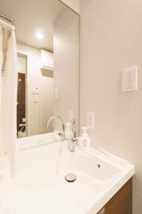 ein Badezimmer mit Waschbecken und Spiegel in der Unterkunft LANG HOTEL Kameido - Vacation STAY 79478v in Tokio + 13 Fotos