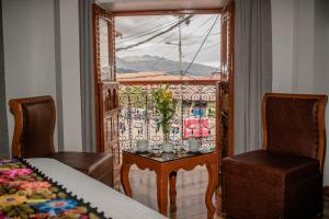 a room with a table and two chairs and a window at Kantu hotel in Cusco