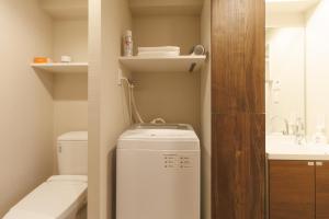 LANG HOTEL Kameido - Vacation STAY 79409v في طوكيو: حمام صغير مع غسالة ومغسلة +16 صورة