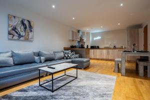 een woonkamer met een blauwe bank en een tafel bij Spacious 2BR Apt - City Centre - Balcony - Parking in Central Station